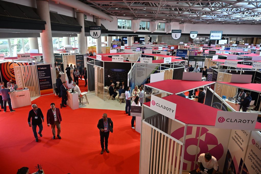 Vue en plongée du hall d’exposition des Assises de la cybersécurité au Grimaldi Forum de Monaco, avec ses stands et ses visiteurs